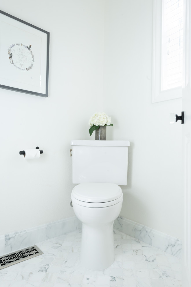 Cette image montre un WC et toilettes traditionnel de taille moyenne avec un placard à porte plane, des portes de placard bleues, WC séparés, un carrelage blanc, du carrelage en marbre, un mur blanc, un sol en marbre, un lavabo encastré, un plan de toilette en marbre, un sol blanc et un plan de toilette blanc.