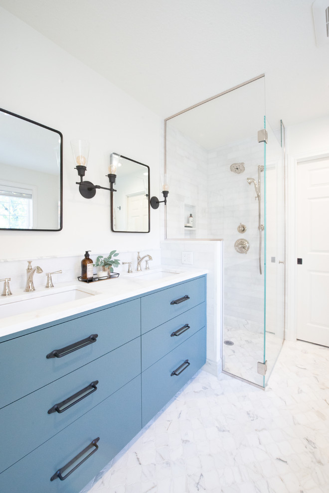 Стильный дизайн: главная ванная комната среднего размера в классическом стиле с плоскими фасадами, синими фасадами, отдельно стоящей ванной, душем без бортиков, раздельным унитазом, белой плиткой, мраморной плиткой, белыми стенами, мраморным полом, врезной раковиной, мраморной столешницей, белым полом, душем с распашными дверями и белой столешницей - последний тренд