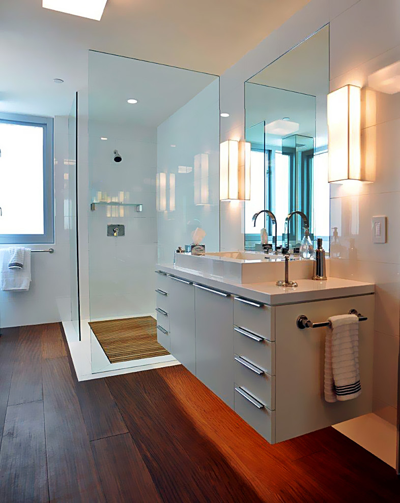 Стильный дизайн: ванная комната в средиземноморском стиле с плоскими фасадами, белыми фасадами, отдельно стоящей ванной, угловым душем, инсталляцией, белыми стенами, темным паркетным полом, настольной раковиной, столешницей из искусственного камня, коричневым полом и душем с распашными дверями - последний тренд