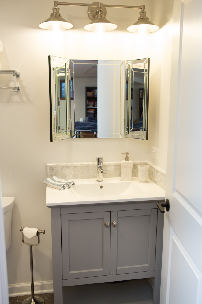 シカゴにあるお手頃価格の小さなトランジショナルスタイルのおしゃれな浴室 (落し込みパネル扉のキャビネット、グレーのキャビネット、一体型トイレ	、白いタイル、セラミックタイル、白い壁、セラミックタイルの床、一体型シンク、珪岩の洗面台、グレーの床、白い洗面カウンター) の写真
