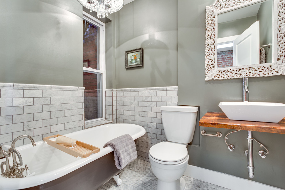 Diseño de cuarto de baño contemporáneo de tamaño medio con lavabo sobreencimera, bañera con patas, paredes grises, baldosas y/o azulejos grises y aseo y ducha