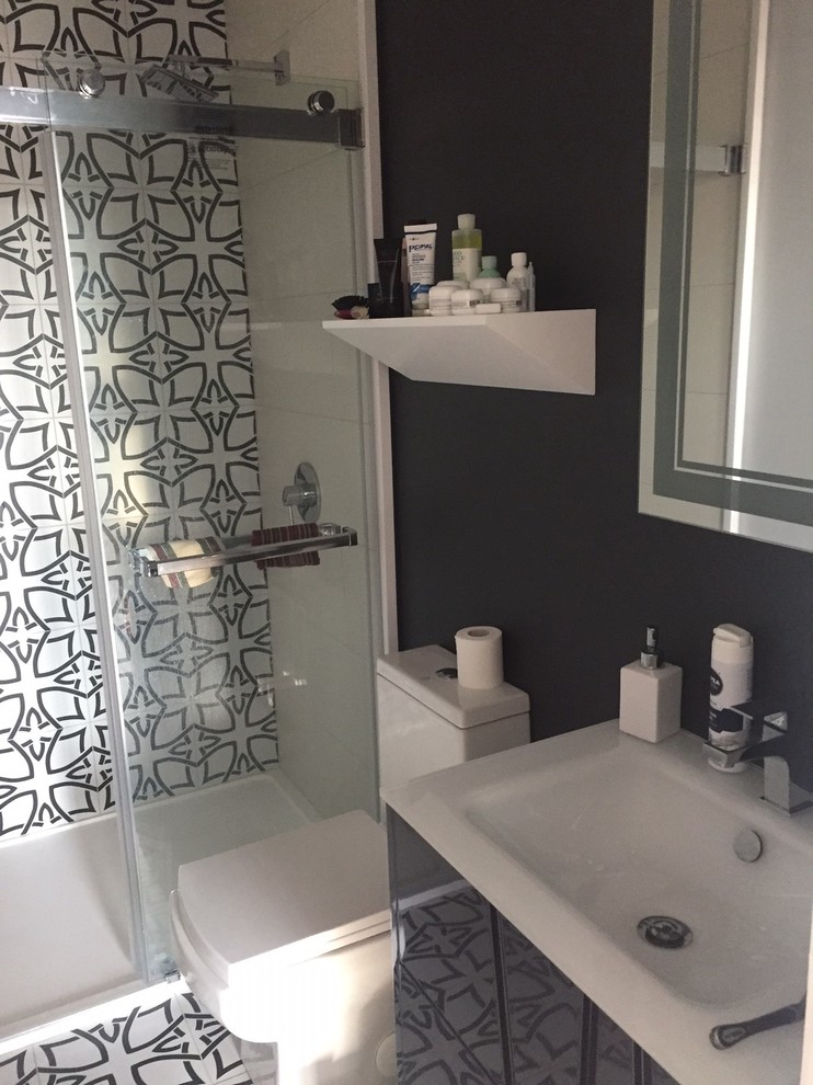 Design ideas for a small shower room bathroom in New York with glass-front cabinets, black cabinets, an alcove shower, a one-piece toilet, multi-coloured tiles, cement tiles, multi-coloured walls, cement flooring, an integrated sink, multi-coloured floors and a sliding door.