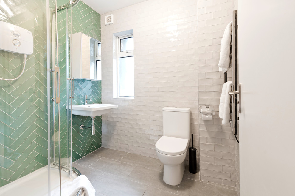 Exempel på ett mellanstort modernt badrum för barn, med släta luckor, en toalettstol med hel cisternkåpa, grön kakel, vit kakel, gröna väggar, ett väggmonterat handfat, vita skåp, en hörndusch, porslinskakel, klinkergolv i porslin, bänkskiva i kvartsit, grått golv och dusch med skjutdörr