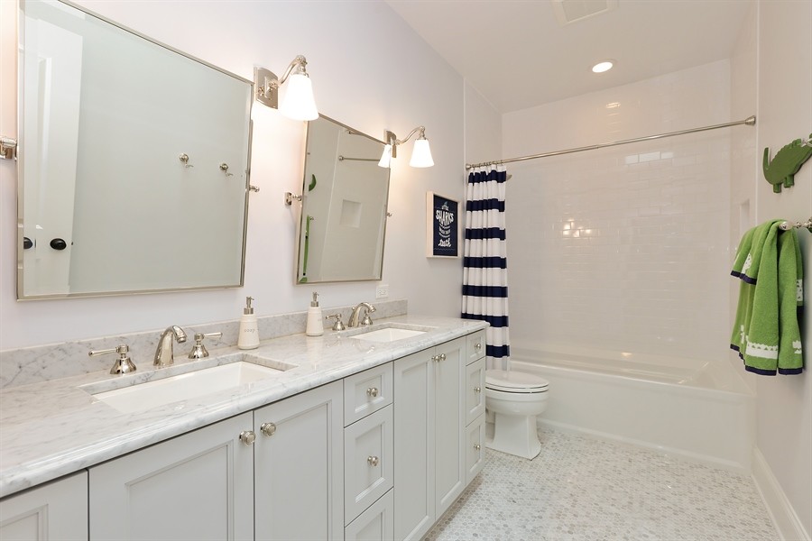 Photo of a medium sized traditional shower room bathroom in Chicago with recessed-panel cabinets, white cabinets, an alcove bath, a shower/bath combination, a two-piece toilet, white tiles, metro tiles, white walls, mosaic tile flooring, a submerged sink, marble worktops, grey floors and a shower curtain.