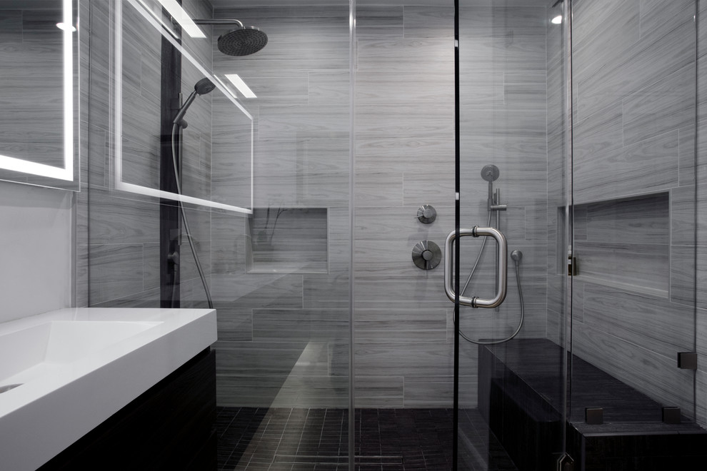 Inspiration for a large modern ensuite bathroom in Los Angeles with flat-panel cabinets, dark wood cabinets, a double shower, a one-piece toilet, grey tiles, porcelain tiles, white walls, light hardwood flooring, an integrated sink, solid surface worktops, beige floors, a hinged door and white worktops.