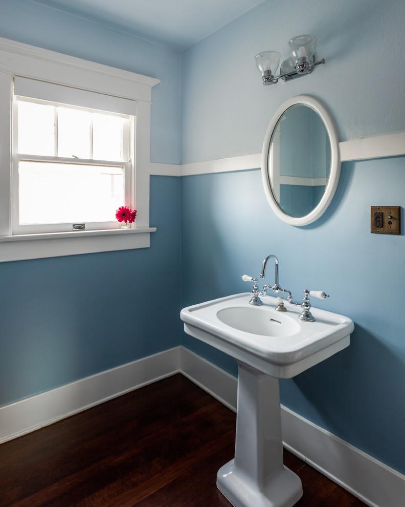 Diseño de cuarto de baño infantil de estilo americano de tamaño medio con paredes azules, suelo de madera en tonos medios, lavabo con pedestal y suelo marrón