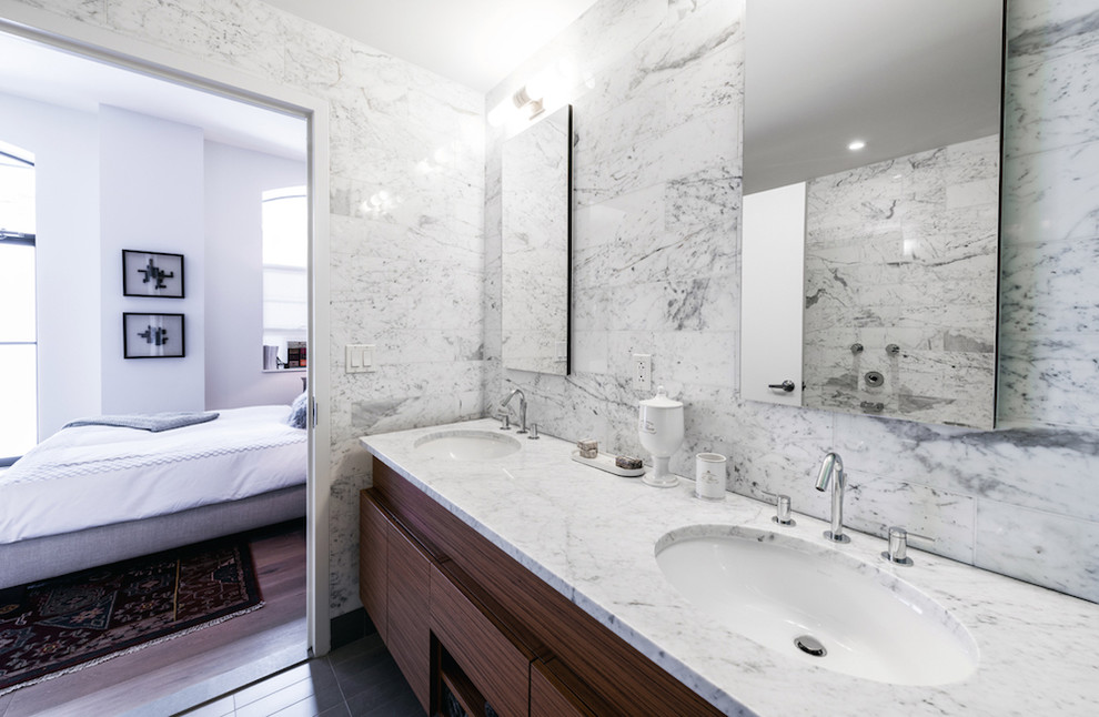 Immagine di una stanza da bagno minimal con ante lisce, ante in legno scuro e lavabo sottopiano