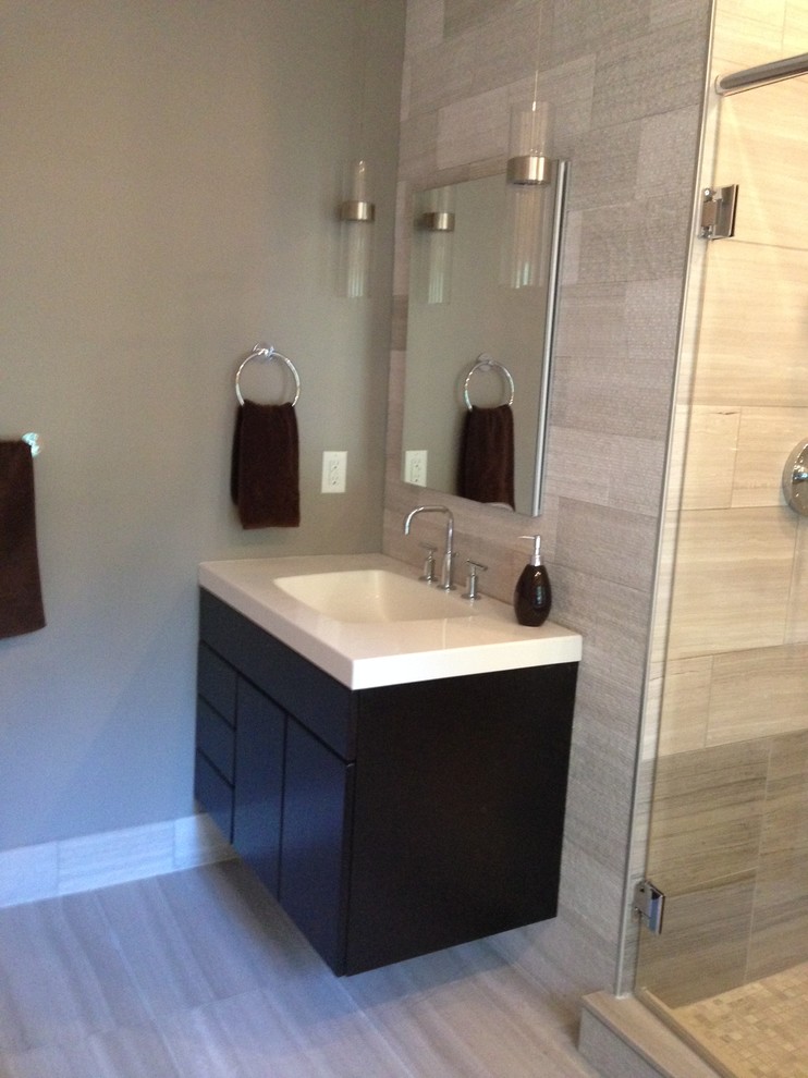 Inspiration for a small transitional master gray tile and stone tile limestone floor bathroom remodel in Cedar Rapids with an integrated sink, flat-panel cabinets, dark wood cabinets, a wall-mount toilet and green walls