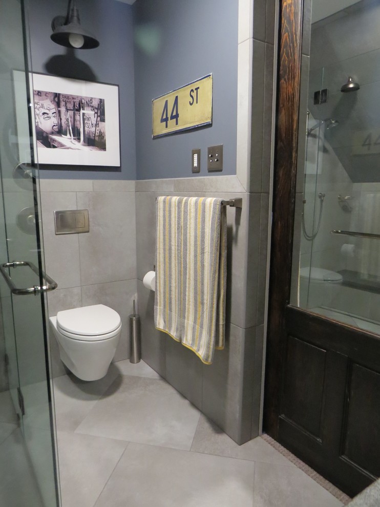 Idéer för ett litet industriellt badrum med dusch, med ett undermonterad handfat, luckor med infälld panel, skåp i mörkt trä, en kantlös dusch, en vägghängd toalettstol, porslinskakel, grå väggar, klinkergolv i porslin och grå kakel