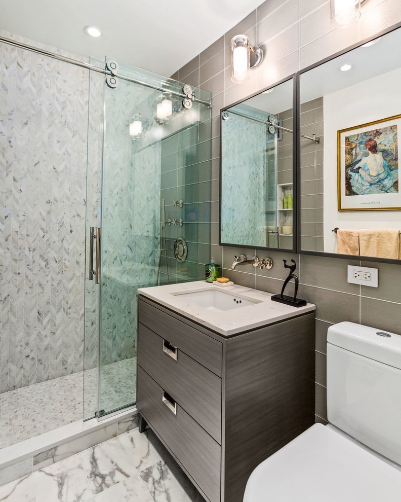 Ispirazione per una piccola stanza da bagno minimalista con consolle stile comò, ante grigie, doccia alcova, WC monopezzo, piastrelle di vetro, pareti bianche, pavimento in marmo, lavabo sottopiano e top in superficie solida