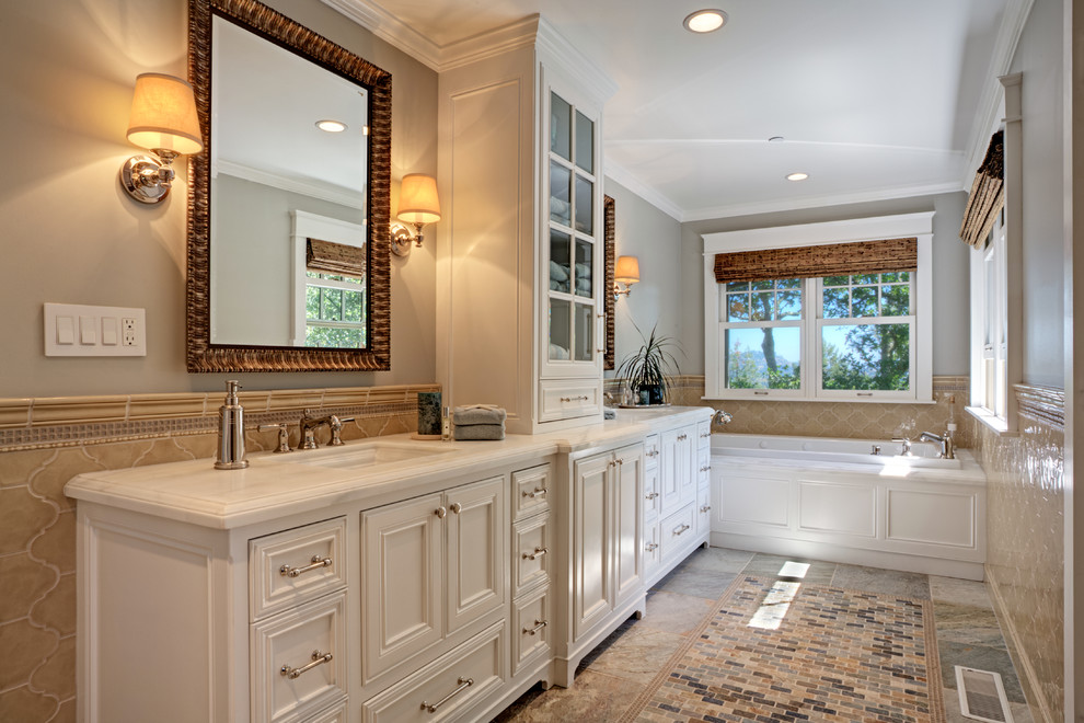 Exempel på ett stort exotiskt en-suite badrum, med luckor med upphöjd panel, vita skåp, ett hörnbadkar, en öppen dusch, en toalettstol med hel cisternkåpa, vit kakel, stenhäll, grå väggar, klinkergolv i keramik, ett nedsänkt handfat, bänkskiva i akrylsten och flerfärgat golv