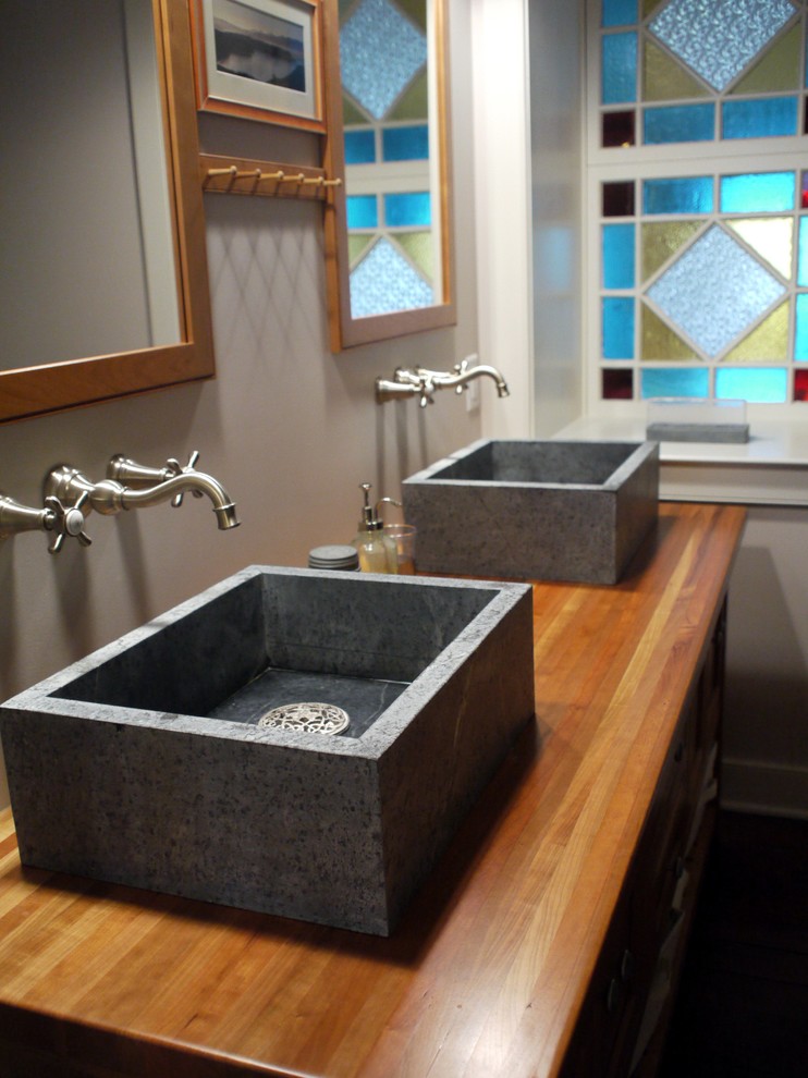 Imagen de cuarto de baño campestre con lavabo sobreencimera y encimera de madera