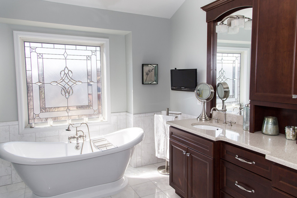 Inspiration for a mid-sized transitional master gray tile, white tile and marble tile marble floor and white floor bathroom remodel in Dallas with an undermount sink, quartz countertops, recessed-panel cabinets, dark wood cabinets, gray walls, a hinged shower door and beige countertops