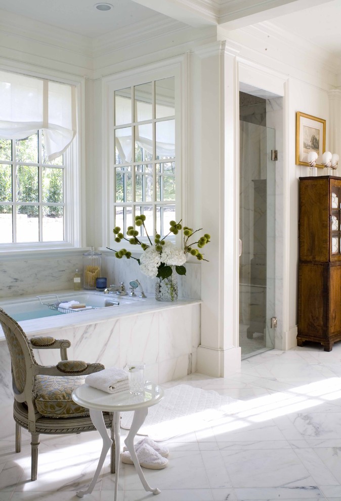 Modelo de cuarto de baño clásico con puertas de armario de madera en tonos medios, ducha empotrada, baldosas y/o azulejos blancos, bañera encastrada sin remate y suelo de mármol