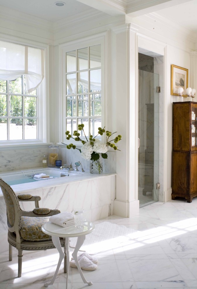 Alcove shower - traditional white tile marble floor alcove shower idea in Dallas with dark wood cabinets and an undermount tub