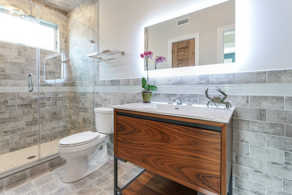 Alcove shower - mid-sized transitional 3/4 brown tile, gray tile and subway tile gray floor alcove shower idea in Philadelphia with flat-panel cabinets, dark wood cabinets, a two-piece toilet, white walls, an integrated sink, quartz countertops and a hinged shower door