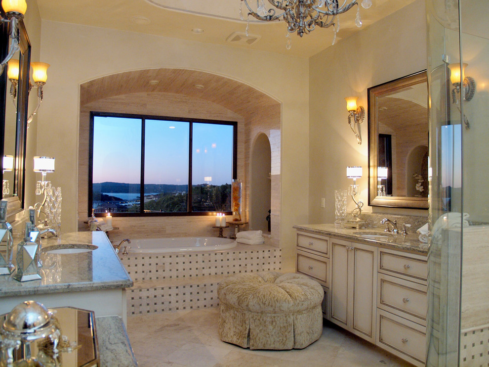 Design ideas for a mediterranean bathroom in Austin with a submerged sink, recessed-panel cabinets, beige cabinets, a built-in bath and beige tiles.