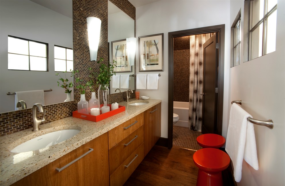 Cette image montre une salle de bain principale traditionnelle en bois brun de taille moyenne avec un plan de toilette en granite, un placard à porte plane, un carrelage beige, un carrelage marron, un carrelage en pâte de verre, un mur blanc, un sol en bois brun, un lavabo encastré, WC à poser, un sol marron, une baignoire en alcôve, un combiné douche/baignoire et une cabine de douche avec un rideau.