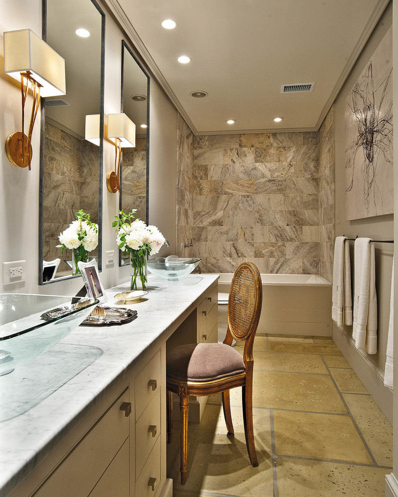 Modern inredning av ett litet en-suite badrum, med ett fristående handfat, släta luckor, vita skåp, bänkskiva i onyx, ett platsbyggt badkar, en dusch i en alkov, en toalettstol med separat cisternkåpa, brun kakel, stenkakel, grå väggar och betonggolv