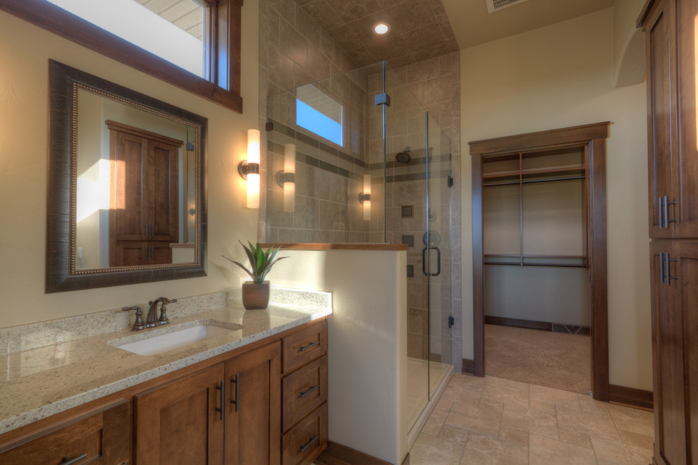 Cette photo montre une grande salle de bain principale chic en bois brun avec un lavabo posé, un placard à porte plane, un plan de toilette en granite, une douche d'angle, un carrelage beige, des carreaux de céramique, un mur beige et un sol en carrelage de céramique.