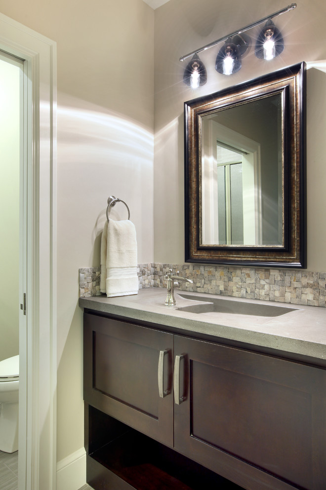 Example of a transitional stone tile bathroom design in Grand Rapids with an integrated sink and concrete countertops