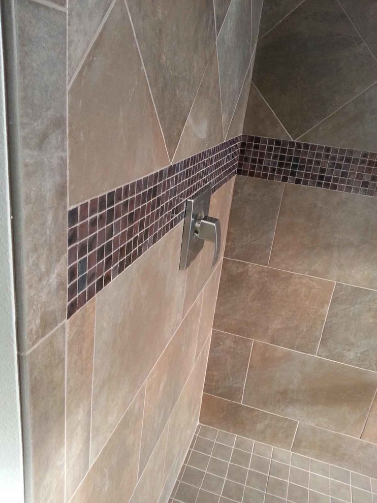 Inspiration for a large transitional master brown tile and ceramic tile porcelain tile doorless shower remodel in Milwaukee with shaker cabinets, dark wood cabinets, an undermount tub and beige walls