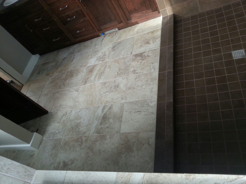 Cette image montre une grande salle de bain principale traditionnelle en bois foncé avec une douche ouverte, un carrelage marron, des carreaux de céramique, un placard à porte shaker, une baignoire encastrée, un mur beige et un sol en carrelage de porcelaine.