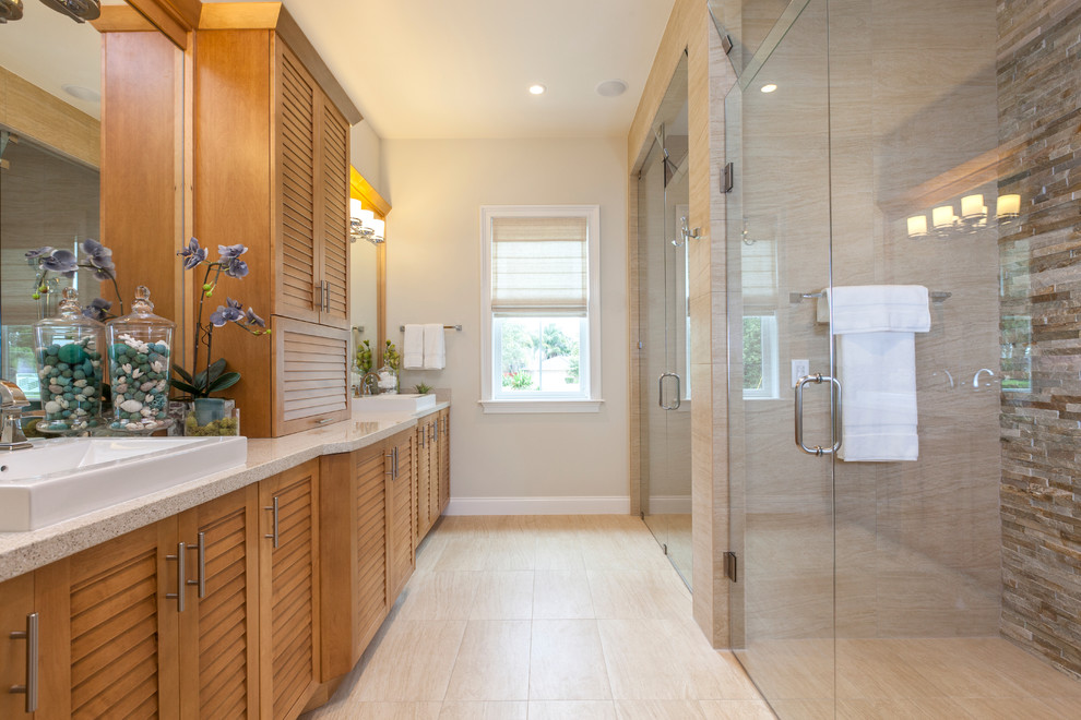 タンパにあるトランジショナルスタイルのおしゃれな浴室 (御影石の洗面台、ルーバー扉のキャビネット、ベッセル式洗面器) の写真