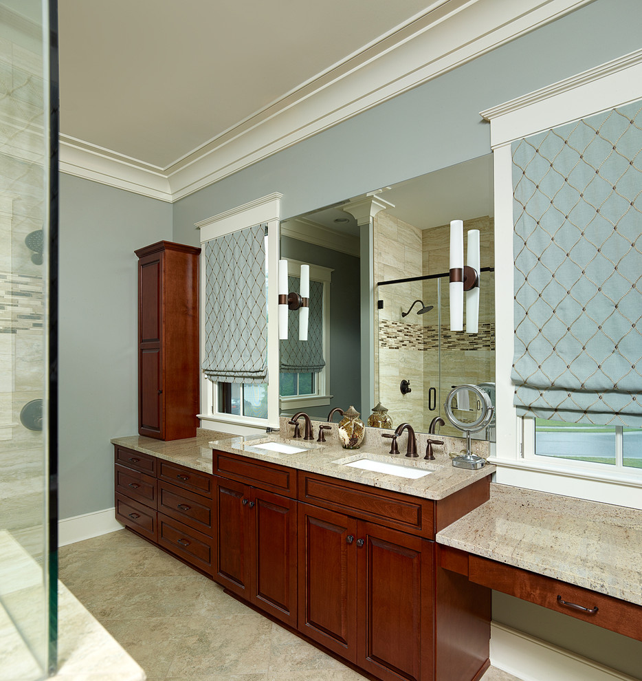Klassisches Badezimmer En Suite mit Unterbauwaschbecken, profilierten Schrankfronten, dunklen Holzschränken, beigen Fliesen, Porzellanfliesen, blauer Wandfarbe und Porzellan-Bodenfliesen in Charleston