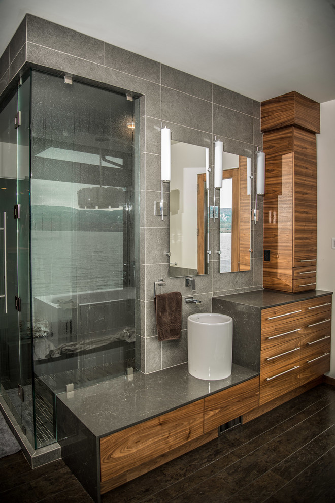 バンクーバーにあるモダンスタイルのおしゃれな浴室 (ベッセル式洗面器、フラットパネル扉のキャビネット、中間色木目調キャビネット、珪岩の洗面台、オープン型シャワー、グレーのタイル、磁器タイル) の写真