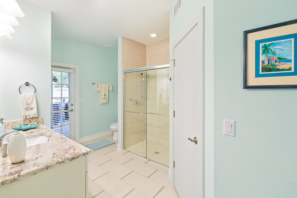 Ispirazione per una stanza da bagno costiera di medie dimensioni con ante con riquadro incassato, ante bianche, doccia alcova, pareti blu, lavabo sottopiano e top in granito