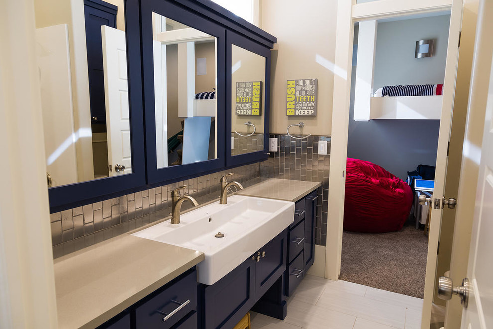 Foto di una stanza da bagno per bambini american style di medie dimensioni con lavabo rettangolare, ante in stile shaker, ante blu, top in quarzite, WC monopezzo, piastrelle beige, piastrelle in gres porcellanato, pareti beige e pavimento in gres porcellanato
