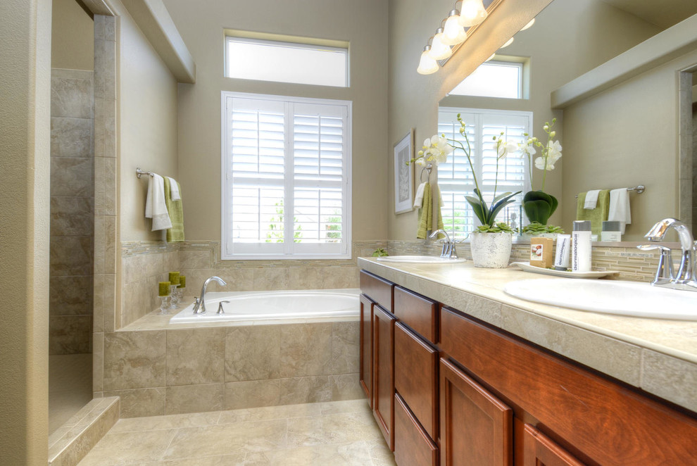 Inspiration for a master beige tile and ceramic tile ceramic tile bathroom remodel in Denver with a drop-in sink, recessed-panel cabinets, medium tone wood cabinets, tile countertops, a one-piece toilet and beige walls