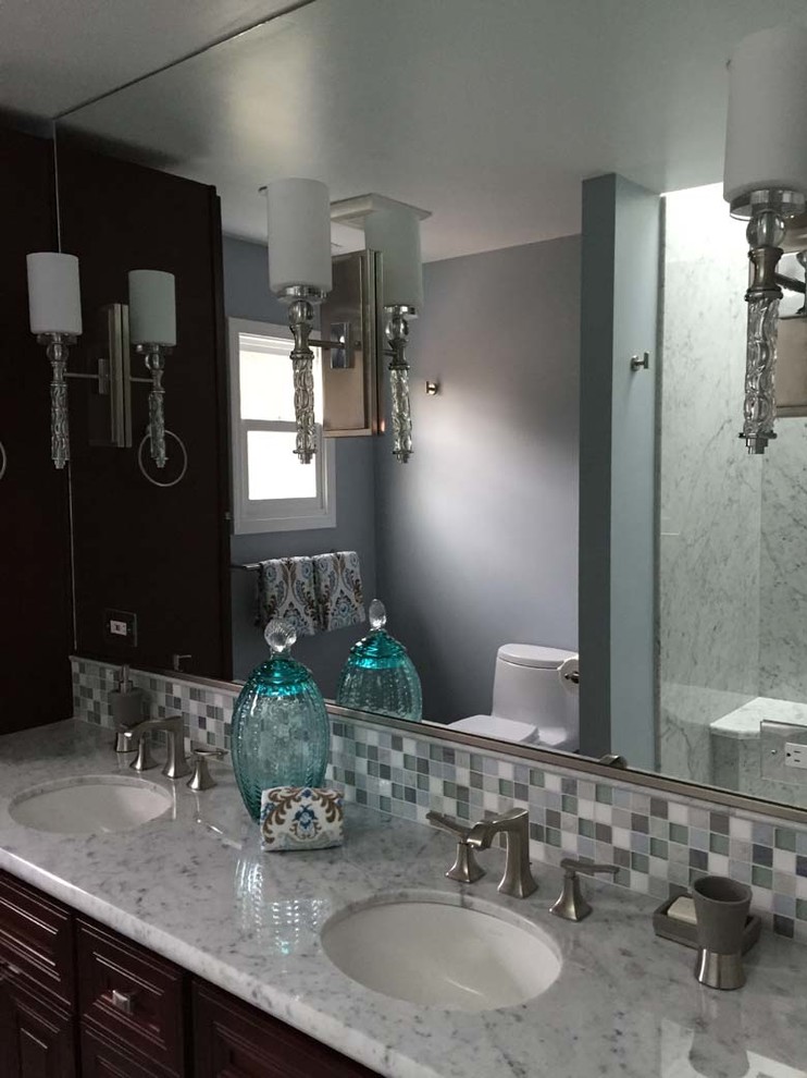 Immagine di una stanza da bagno padronale design di medie dimensioni con ante con riquadro incassato, ante in legno bruno, piastrelle a mosaico, pareti blu e pavimento in marmo