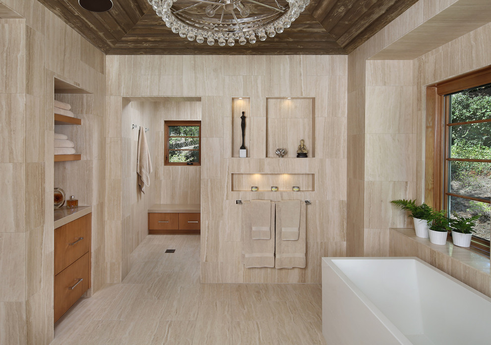 Exempel på ett modernt badrum, med släta luckor, skåp i mellenmörkt trä, en dusch i en alkov, beige kakel, ett undermonterad handfat, ett fristående badkar och travertinkakel