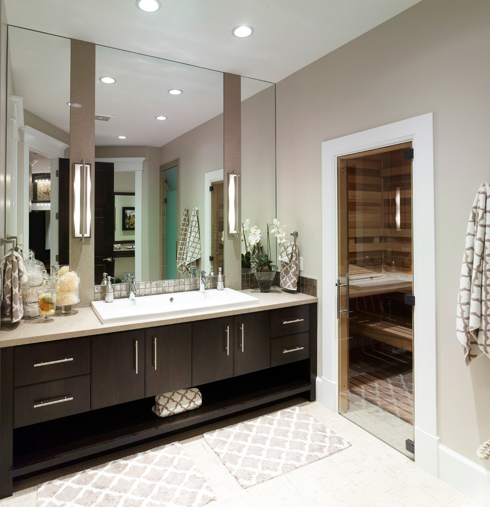 This is an example of a medium sized classic ensuite bathroom in Salt Lake City with flat-panel cabinets, dark wood cabinets, beige walls, ceramic flooring, a built-in sink, limestone worktops and beige floors.
