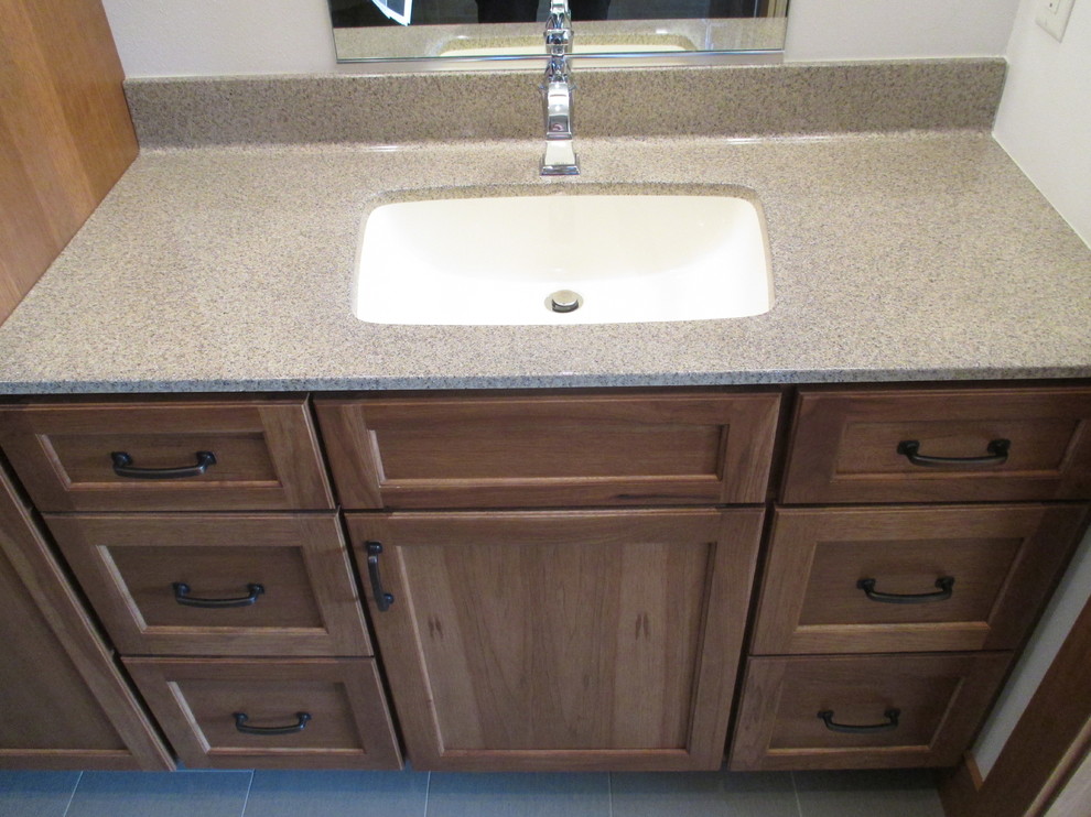 Photo of a medium sized traditional bathroom in Other with recessed-panel cabinets, medium wood cabinets, white walls and a submerged sink.