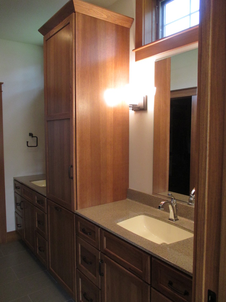 Inredning av ett klassiskt mellanstort badrum, med luckor med infälld panel, skåp i mellenmörkt trä, vita väggar och ett undermonterad handfat