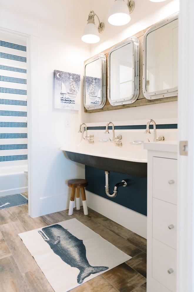 Ispirazione per una stanza da bagno costiera con piastrelle blu, piastrelle bianche, pareti bianche e lavabo sospeso