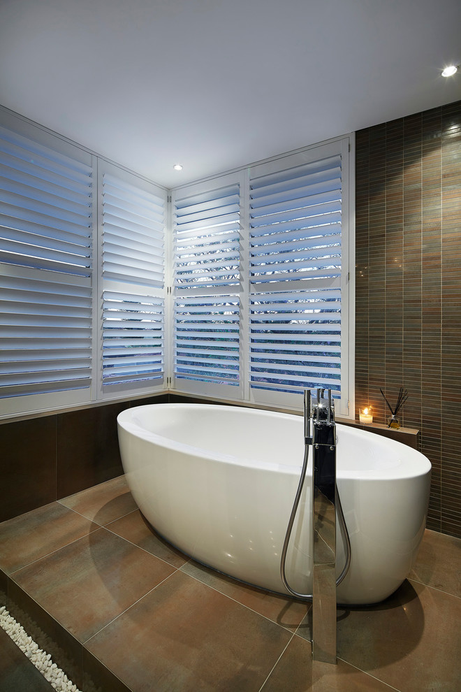Diseño de cuarto de baño actual con baldosas y/o azulejos marrones y paredes marrones