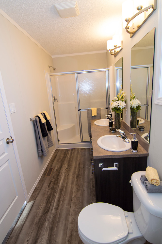 Exempel på ett mellanstort modernt en-suite badrum, med ett nedsänkt handfat, luckor med upphöjd panel, grå skåp, laminatbänkskiva, en dubbeldusch, en toalettstol med hel cisternkåpa, brun kakel, tunnelbanekakel, vita väggar och linoleumgolv