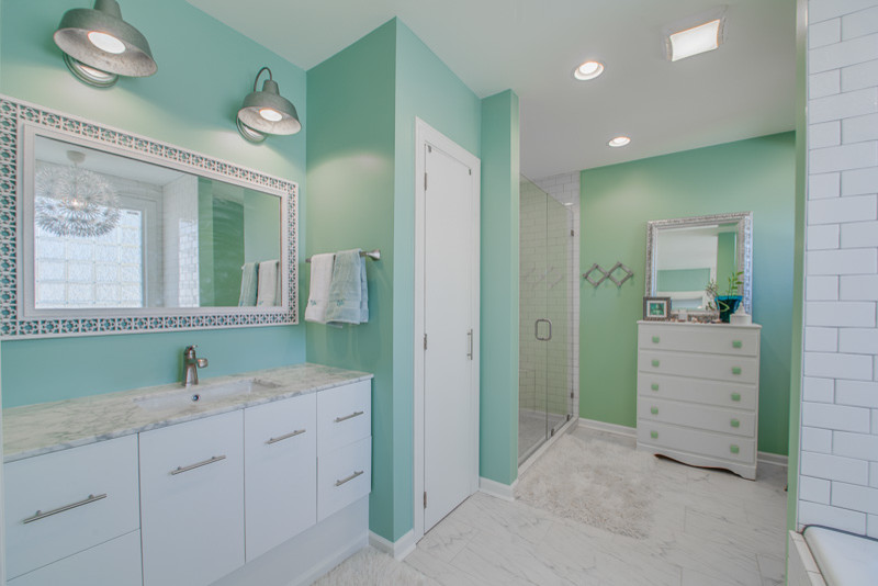 Imagen de cuarto de baño contemporáneo de tamaño medio con lavabo bajoencimera, armarios con paneles lisos, puertas de armario blancas, encimera de granito, baldosas y/o azulejos blancos, paredes verdes y suelo de mármol
