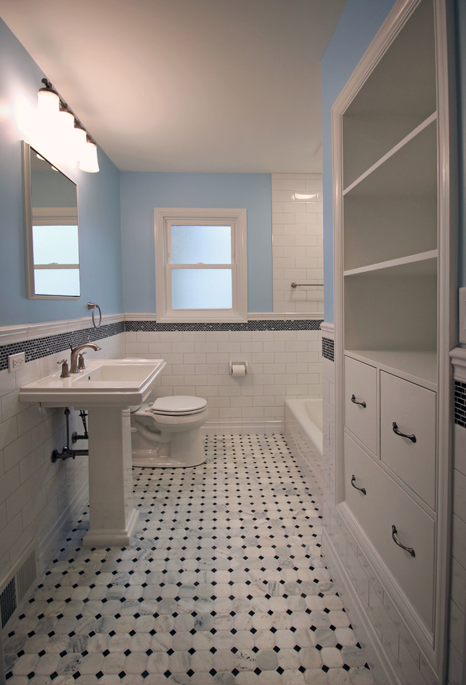 Inspiration pour une salle de bain traditionnelle de taille moyenne avec un lavabo de ferme, un combiné douche/baignoire, mosaïque, un mur bleu, un sol en marbre, un placard à porte plane, des portes de placard blanches et un carrelage noir et blanc.