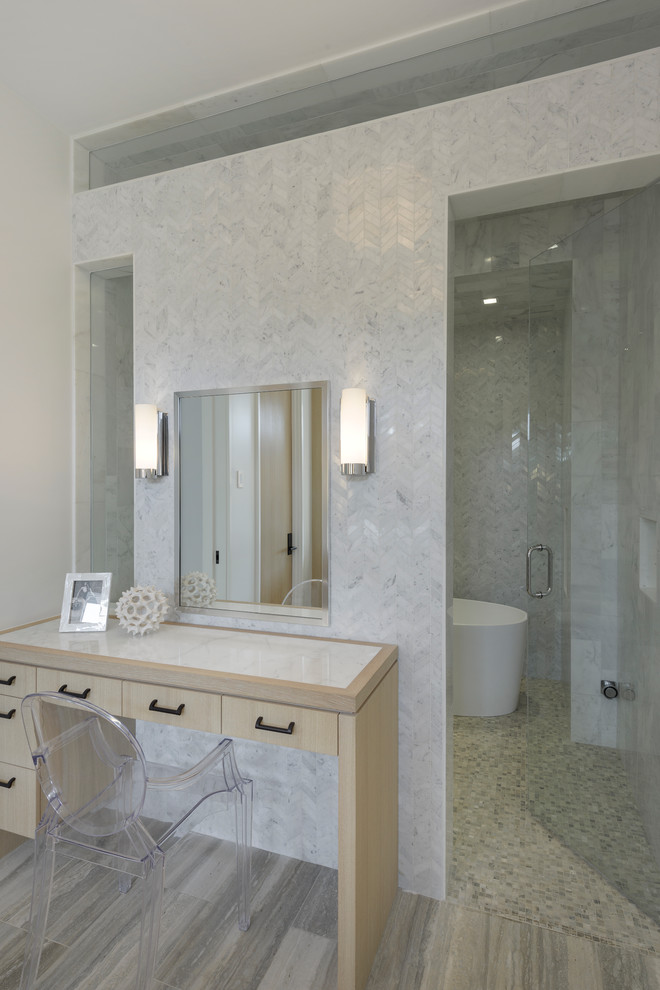 Пример оригинального дизайна: большая главная ванная комната в стиле модернизм с врезной раковиной, плоскими фасадами, светлыми деревянными фасадами, мраморной столешницей, отдельно стоящей ванной, открытым душем, серой плиткой, каменной плиткой, белыми стенами и полом из травертина