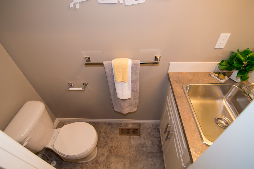 Inspiration för små moderna badrum med dusch, med ett nedsänkt handfat, luckor med upphöjd panel, vita skåp, laminatbänkskiva, en toalettstol med hel cisternkåpa, vit kakel, tunnelbanekakel, beige väggar och linoleumgolv