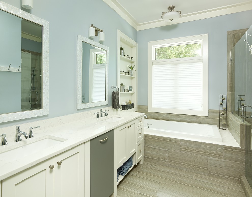 Idée de décoration pour une salle de bain principale design avec un lavabo encastré, un placard à porte shaker, des portes de placard blanches, une baignoire posée, une douche double, un carrelage beige et un mur bleu.