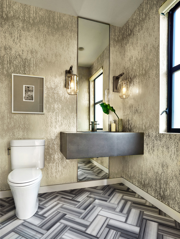 Стильный дизайн: большой туалет в современном стиле с унитазом-моноблоком, разноцветными стенами, мраморным полом, подвесной раковиной и столешницей из бетона - последний тренд