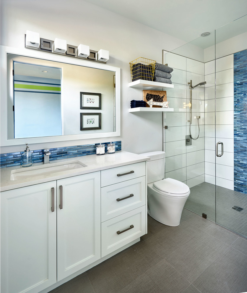 Inspiration för stora moderna badrum med dusch, med skåp i shakerstil, vita skåp, en kantlös dusch, en toalettstol med hel cisternkåpa, blå kakel, glaskakel, vita väggar, marmorgolv, ett undermonterad handfat och bänkskiva i kvarts