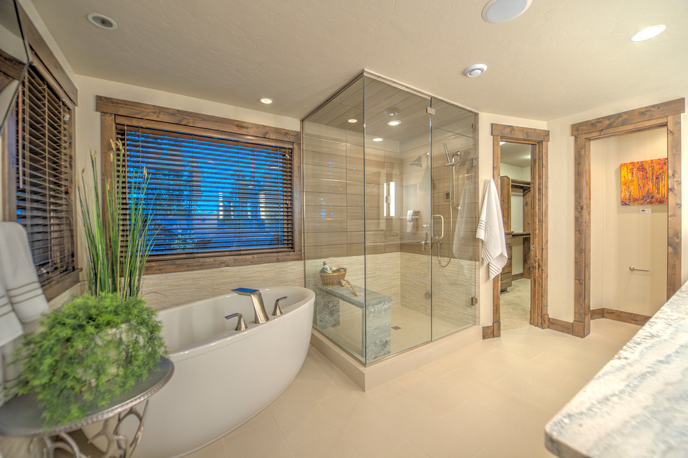 На фото: большая главная ванная комната в стиле рустика с отдельно стоящей ванной, угловым душем, бежевыми стенами, бежевой плиткой и столешницей из гранита с