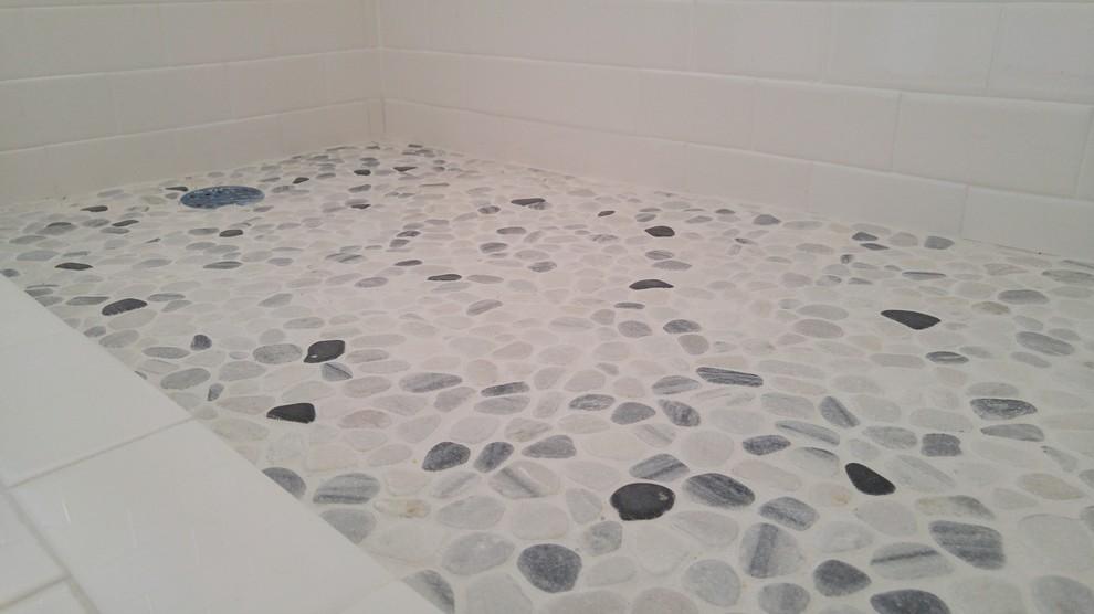 Foto på ett mellanstort minimalistiskt badrum med dusch, med en dusch i en alkov, en toalettstol med hel cisternkåpa, tunnelbanekakel, vita väggar och klinkergolv i småsten